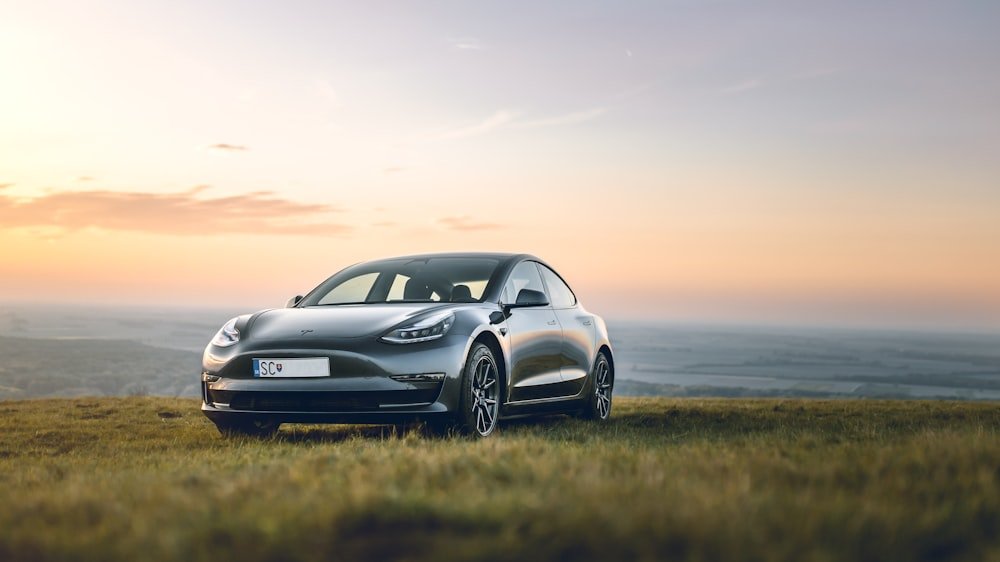 Tesla Model 3 Performance, Project Silent Run, silver electric sedan in an open field at sunset